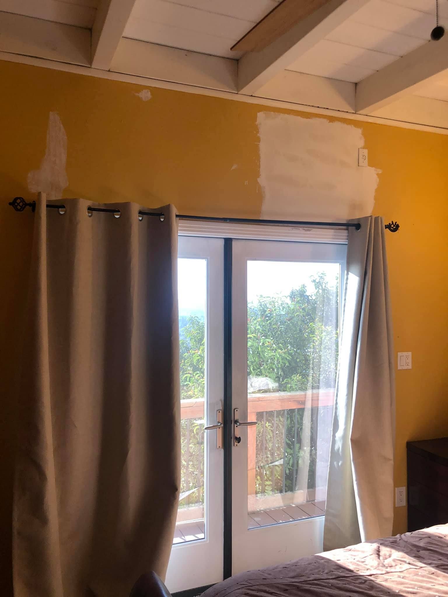 A bedroom with yellow walls and a sliding glass door