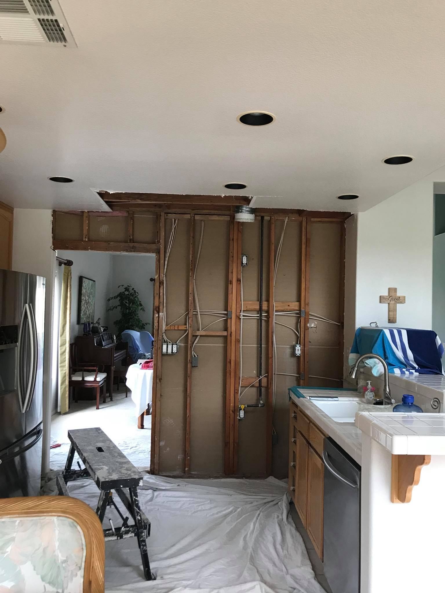 A kitchen with a lot of cabinets being removed and a sink.