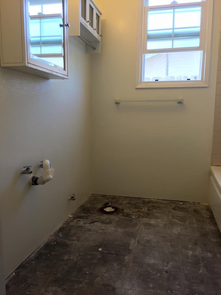 An empty bathroom with a window and a sink.