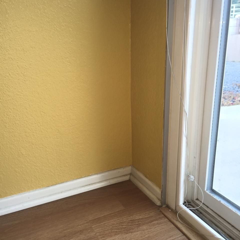 A room with yellow walls and a sliding glass door