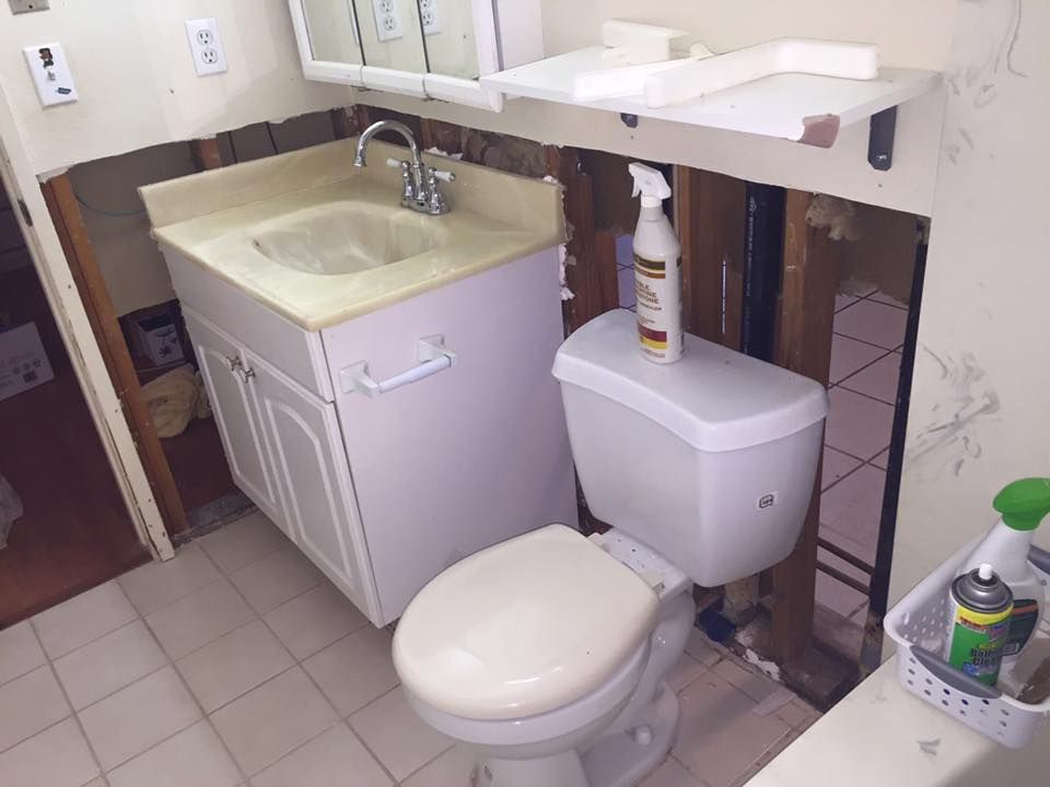 A bathroom with a toilet , sink and mirror