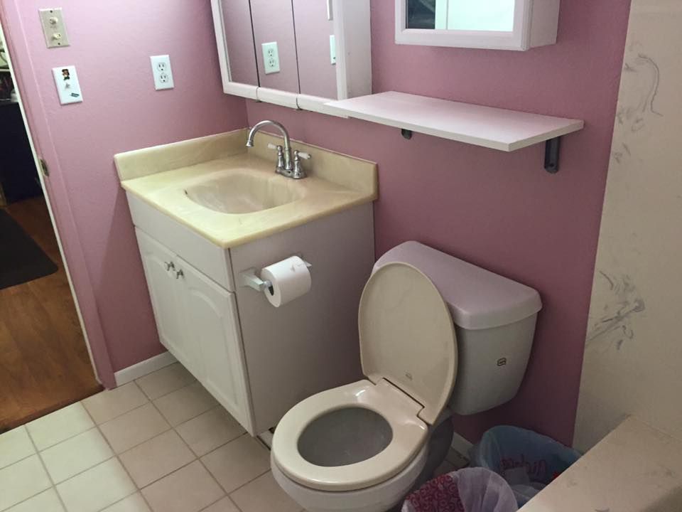 A bathroom with a toilet a sink and a mirror