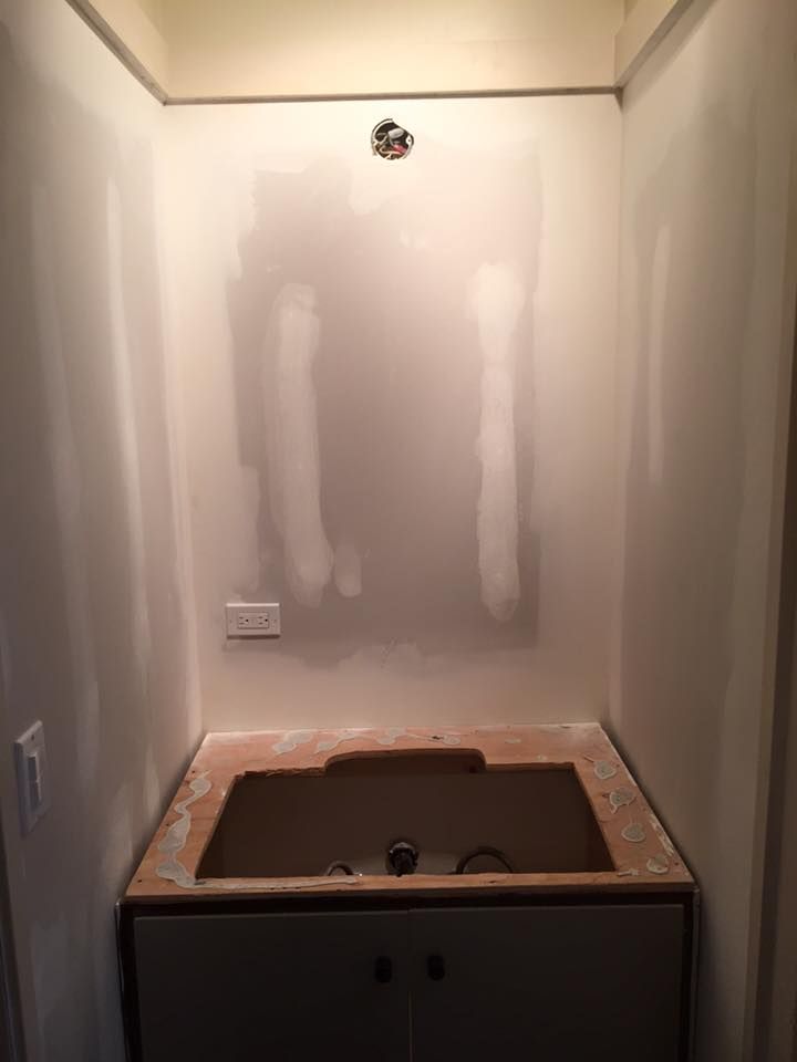 A bathroom with a sink in the middle of the room.