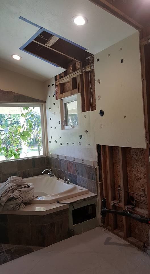 A bathroom under construction with a bathtub and a window.