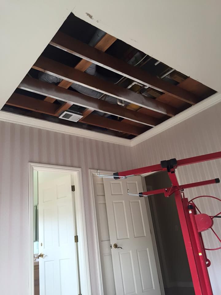 A room with a hole in the ceiling and a red machine