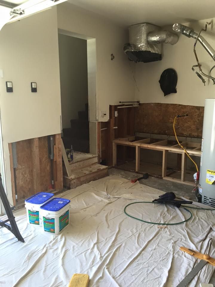 A room that is being remodeled with a ladder and boxes on the floor