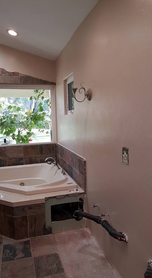 A bathroom with a jacuzzi tub and a window.