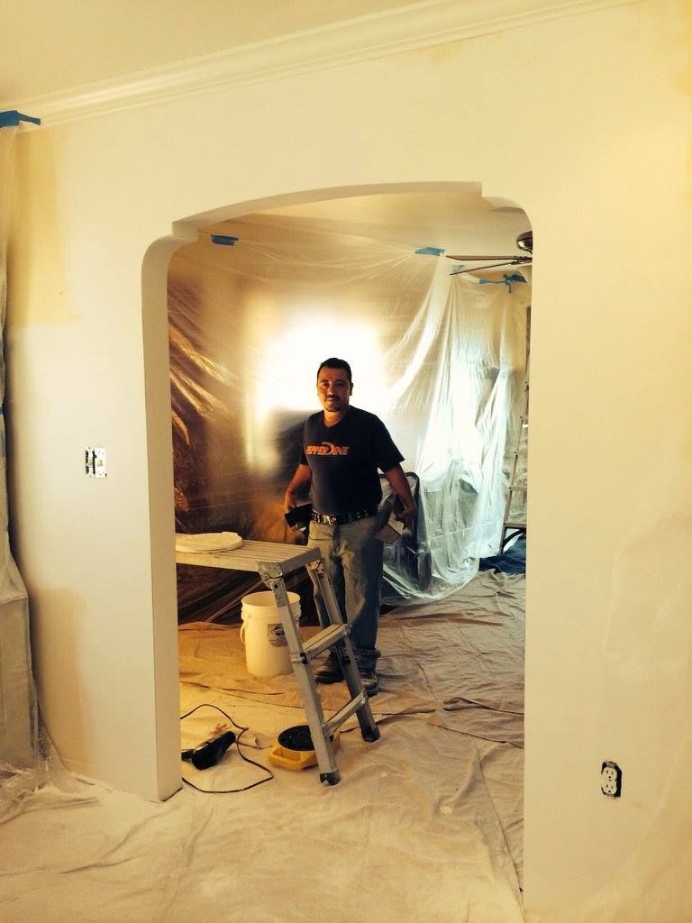 A man is standing in a room with a ladder.