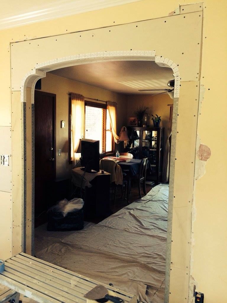 A living room is being remodeled with a large archway