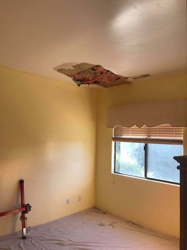 A room with a hole in the ceiling and a window.