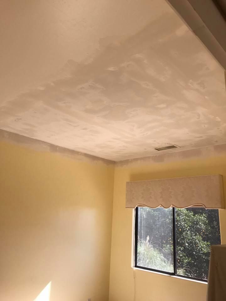 A room with a window and a ceiling that is being painted.
