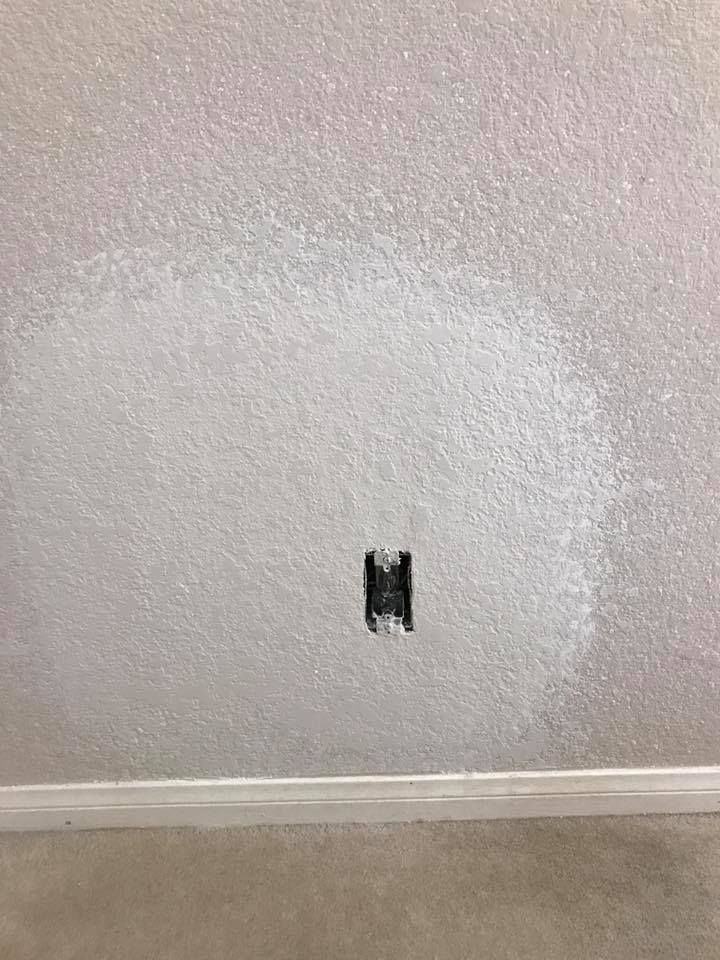 There is a hole in the wall that looks like a light switch.