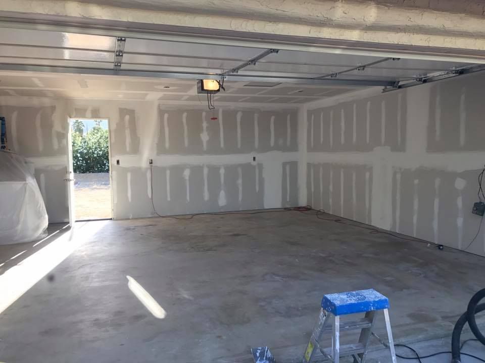 An empty garage with a ladder in the middle of it.