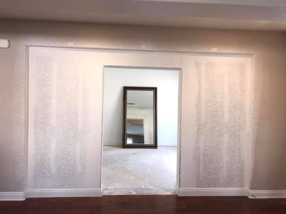 An empty room with a mirror in the middle of it
