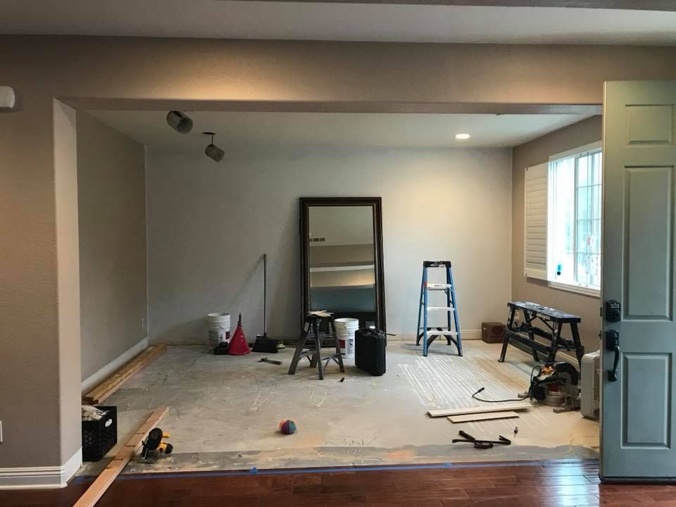 A room with a mirror and a ladder in it is being remodeled.