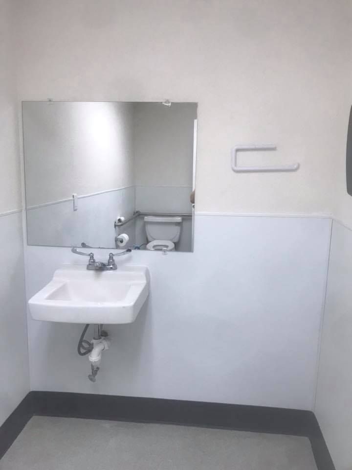 A bathroom with a sink , toilet and mirror.