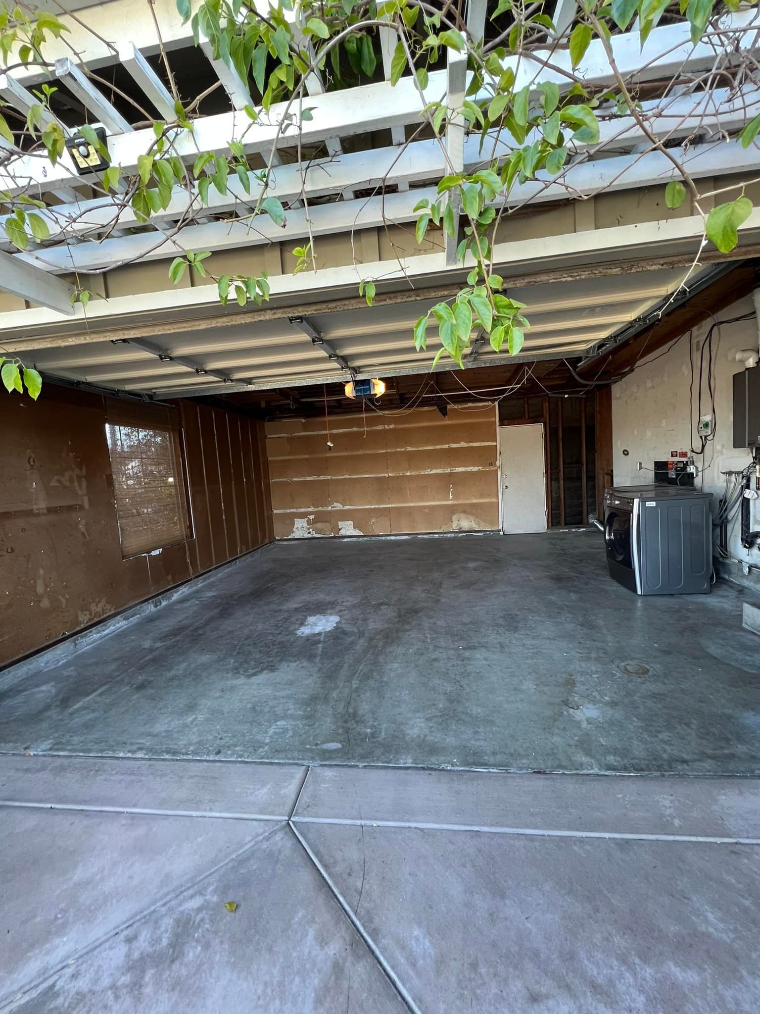 An empty garage with a pergola and a door.