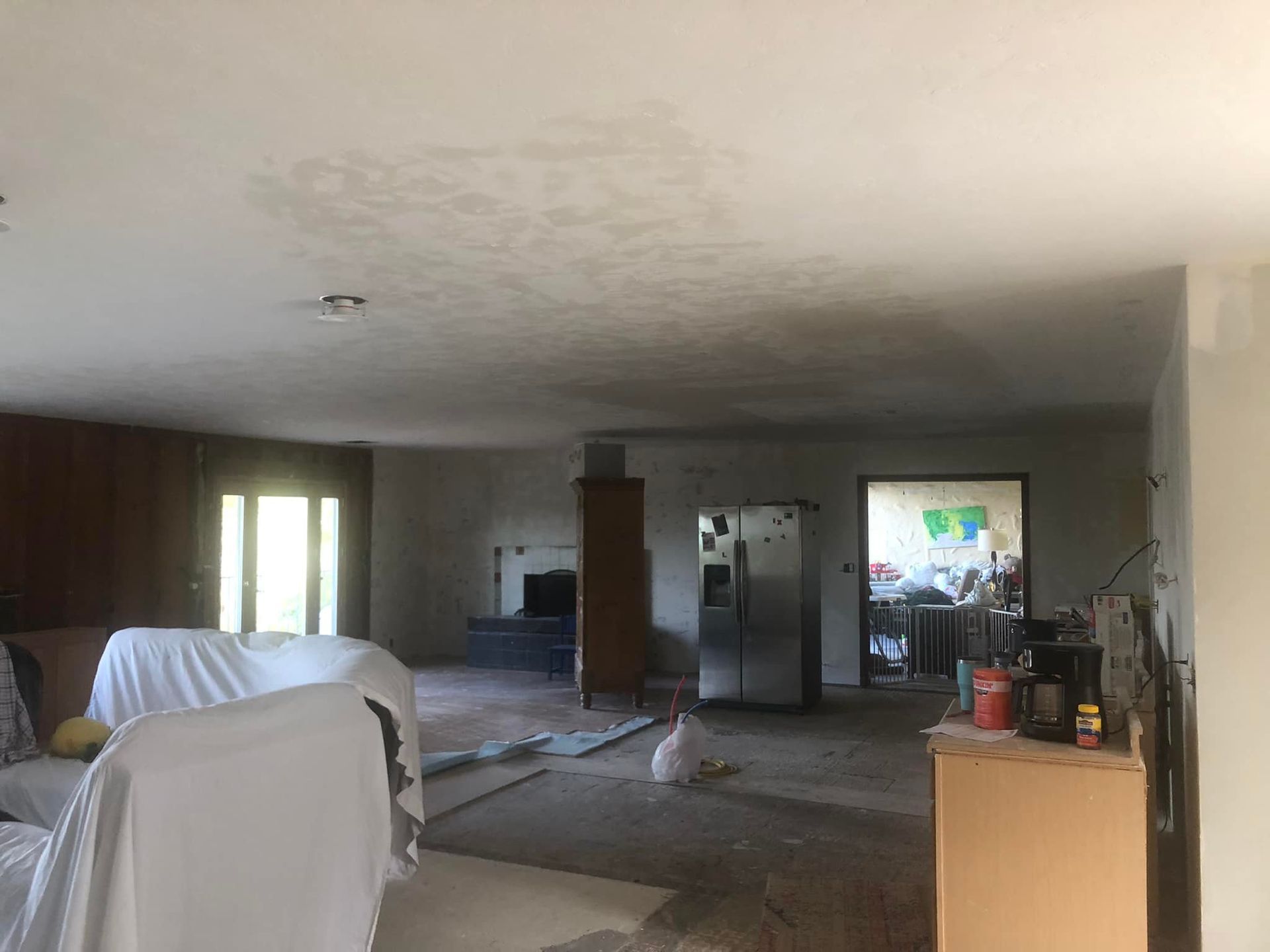 A large room with a couch and a refrigerator in it.