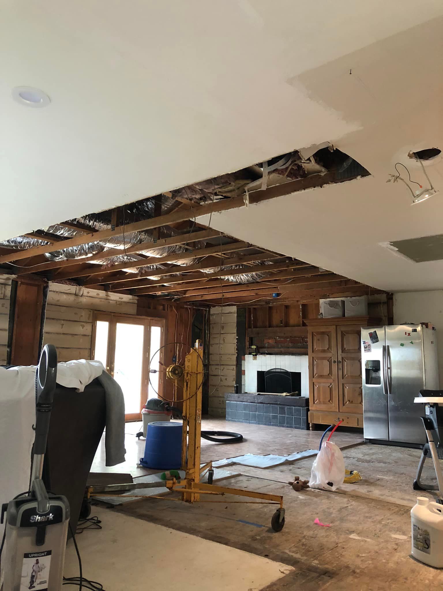 A living room with a ceiling that is being remodeled.