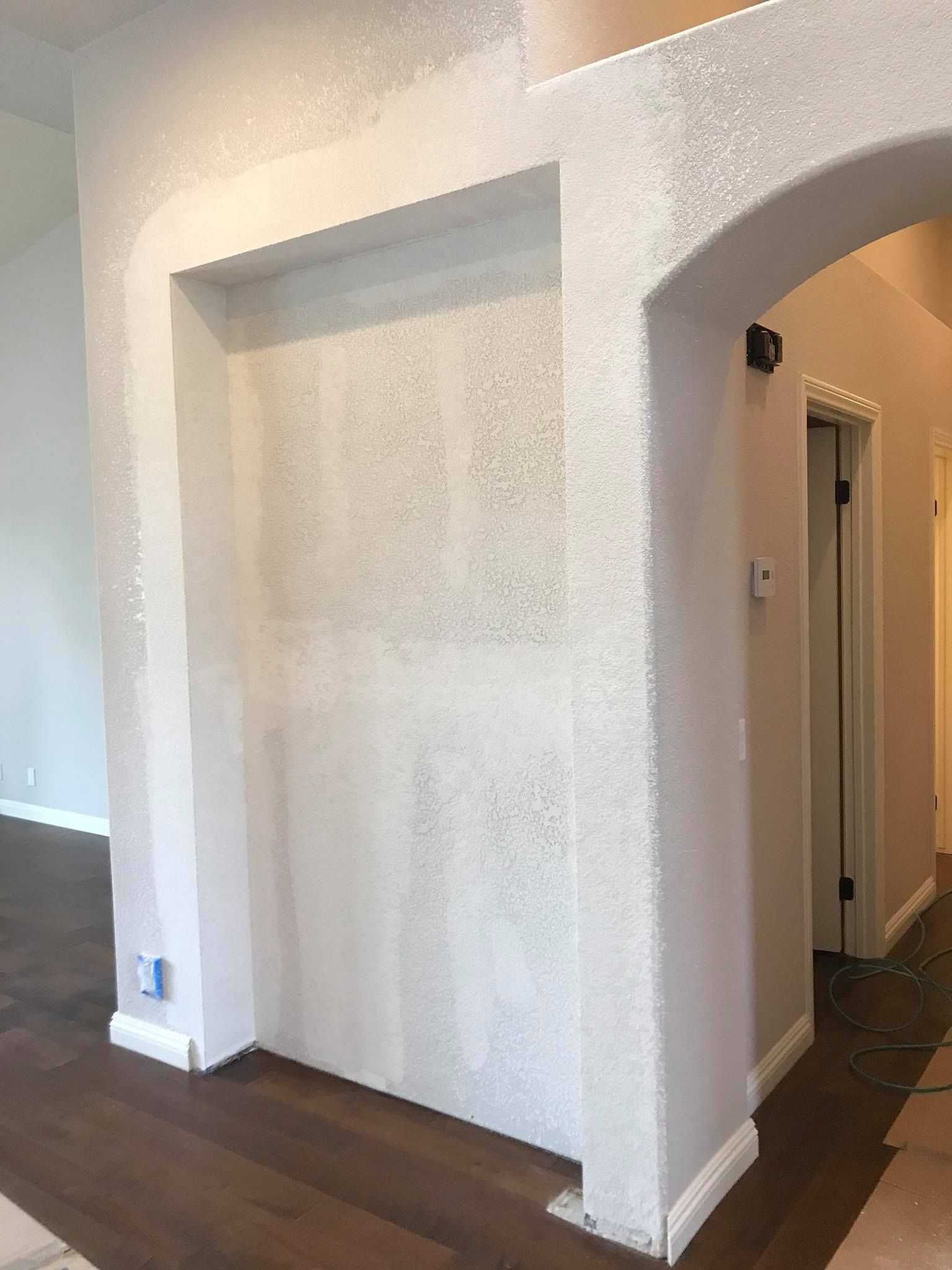 A white wall with a door in the middle of a room.