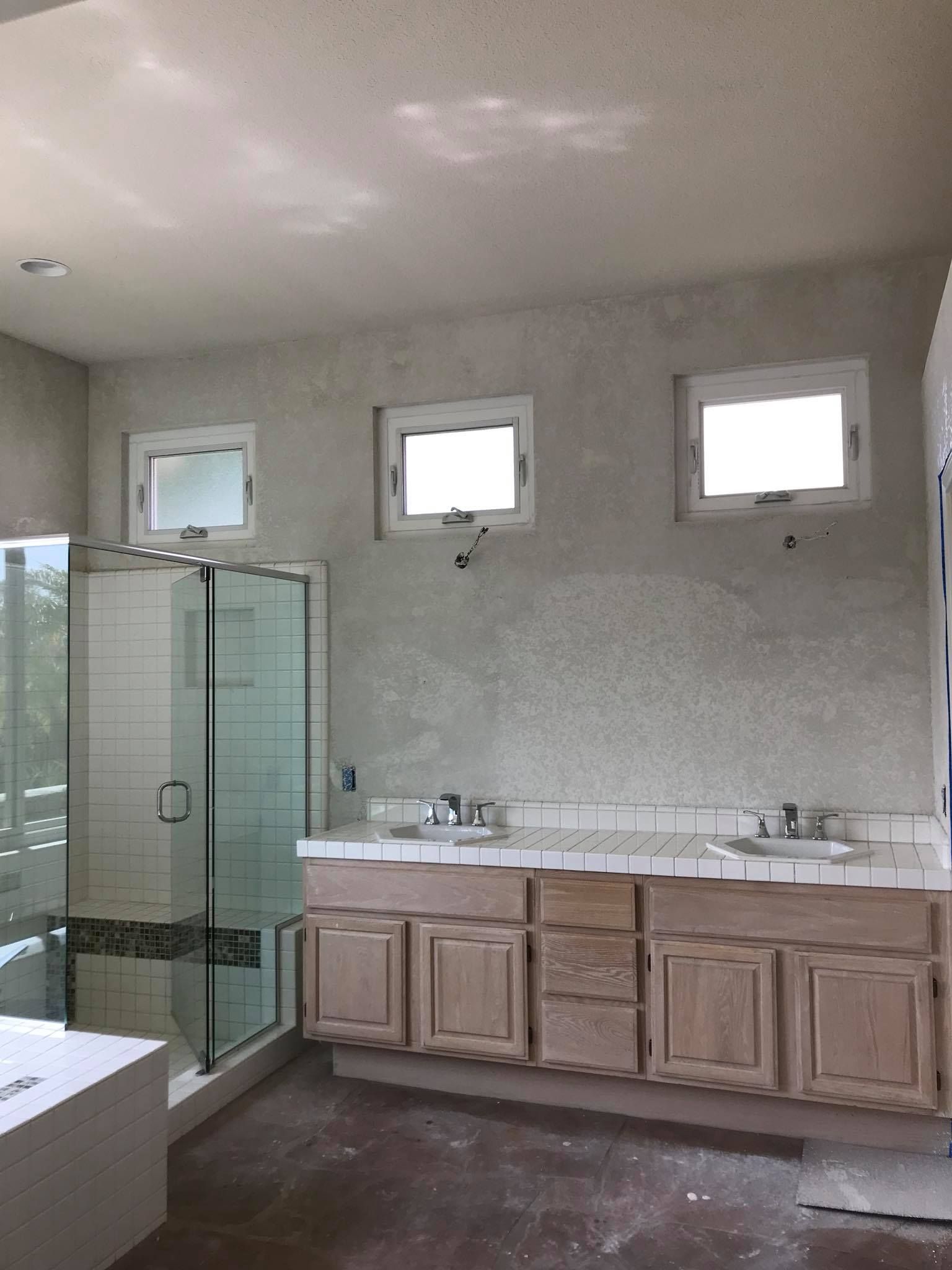 A bathroom with two sinks and a walk in shower.