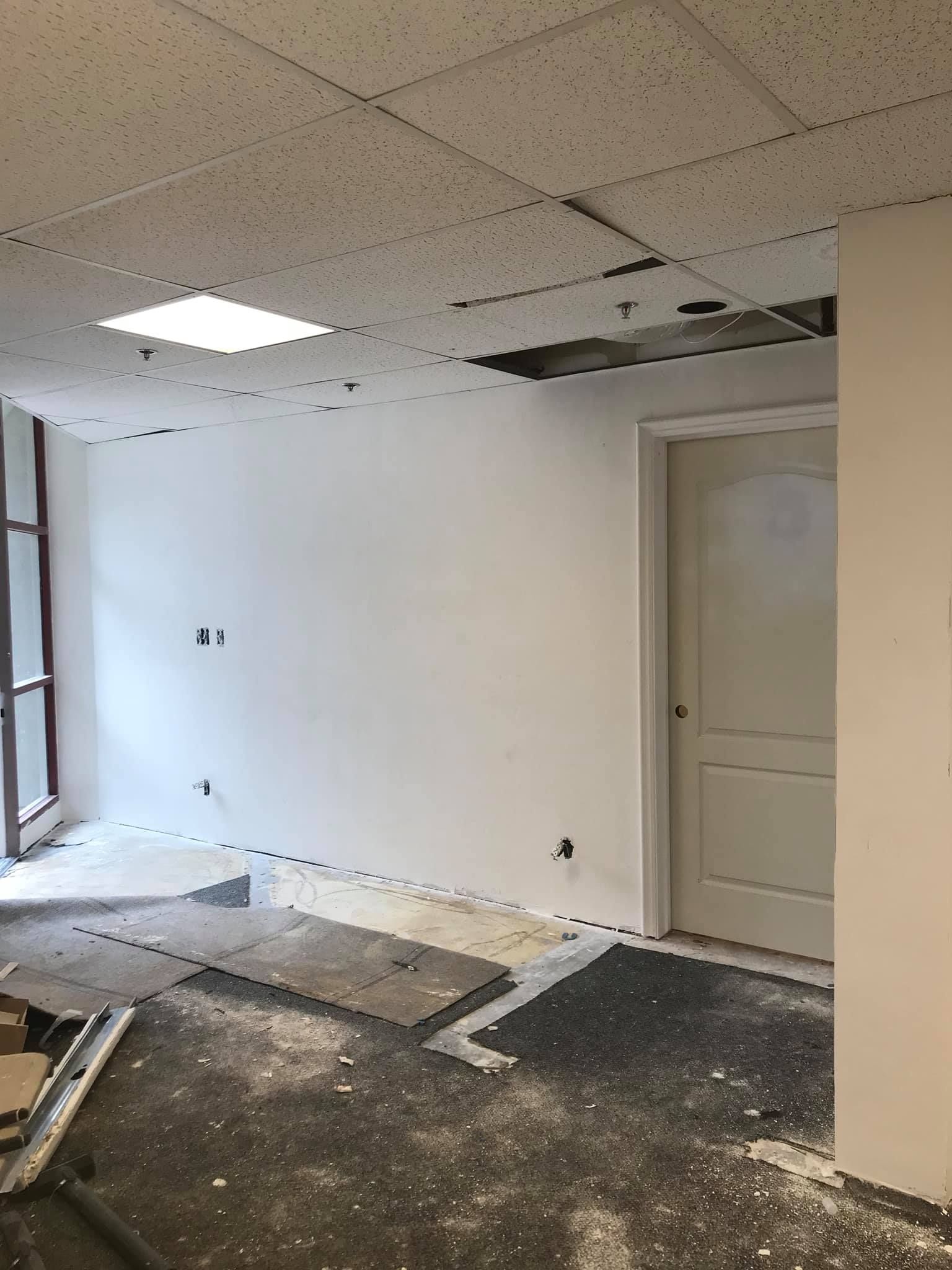 A room with a door and a ceiling that is being remodeled.