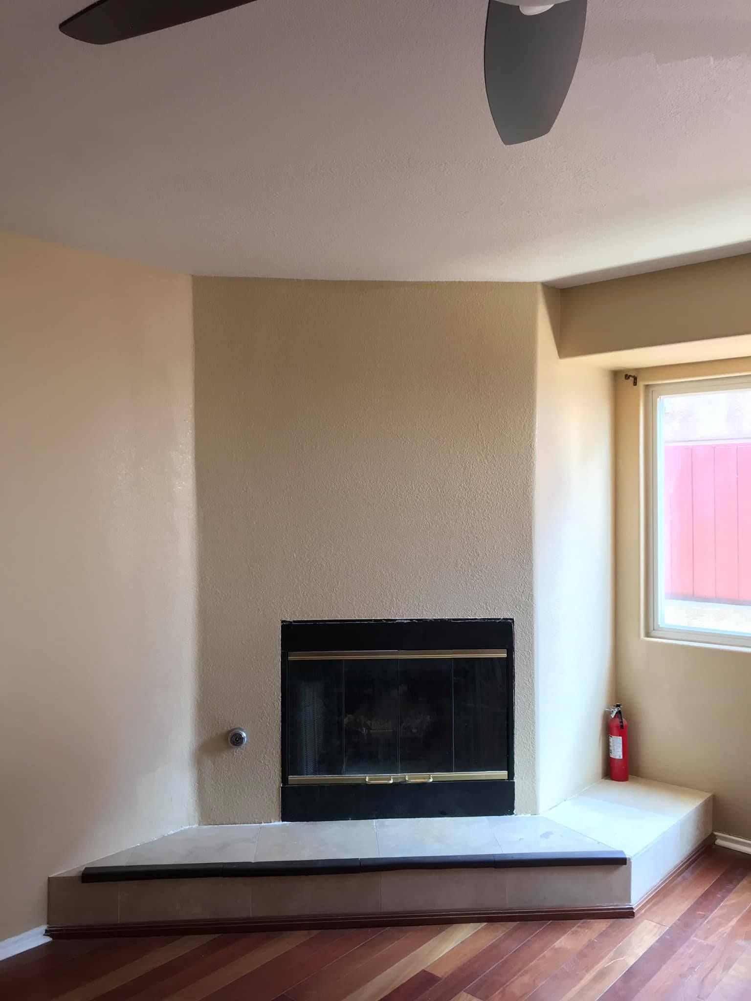 A living room with a fireplace and a ceiling fan