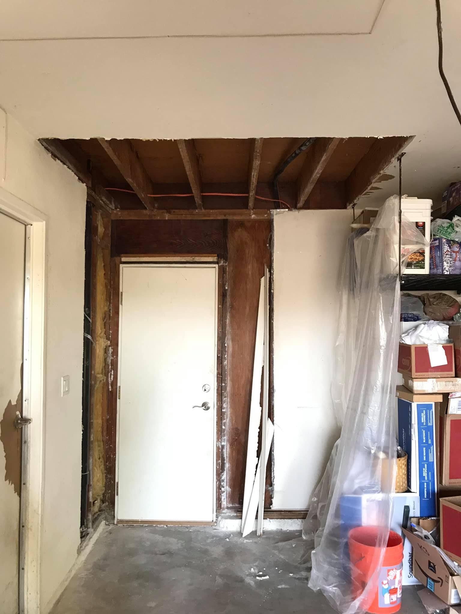 A room with a door and a bucket in it