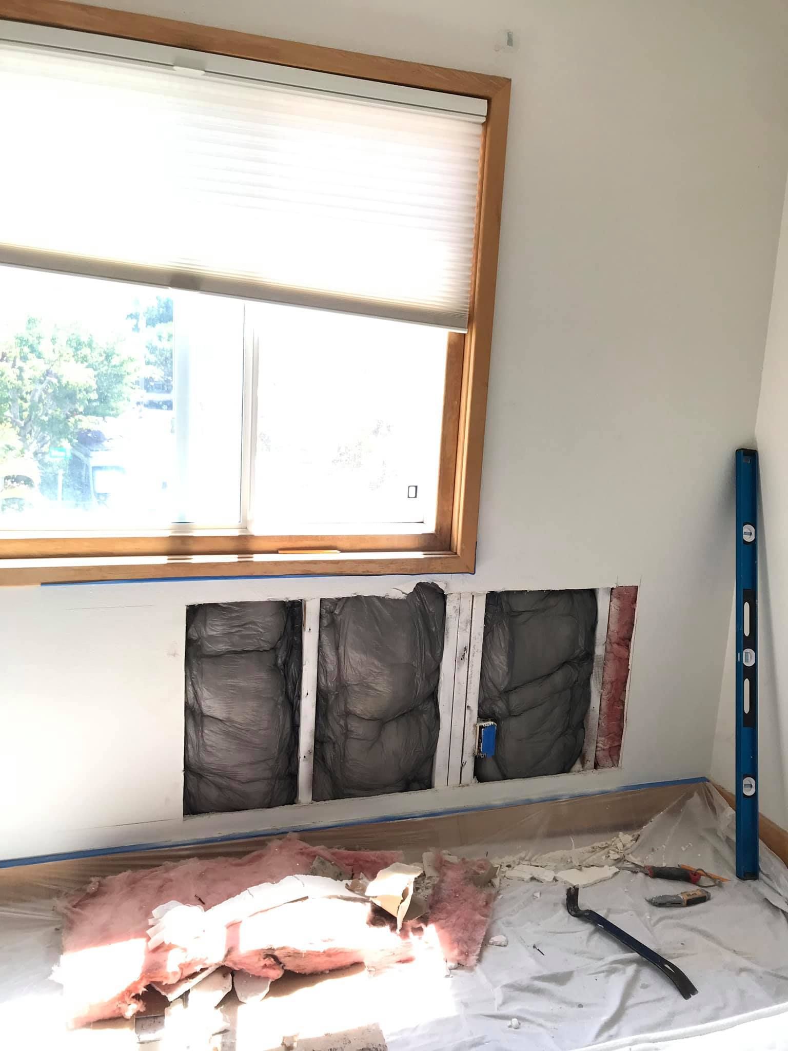 A room with a window and a level on the floor.