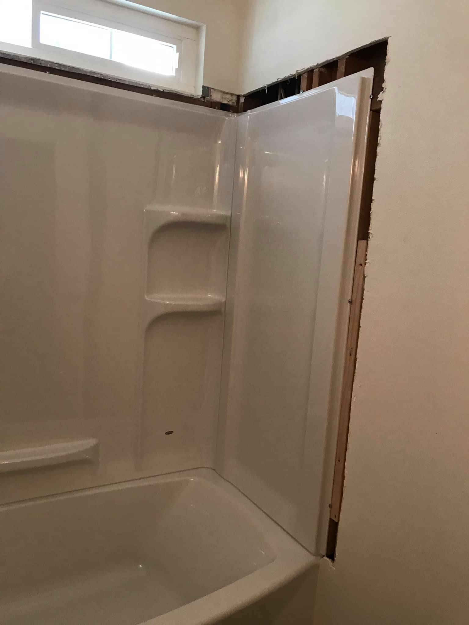 A bathroom with a bathtub and a shower stall.