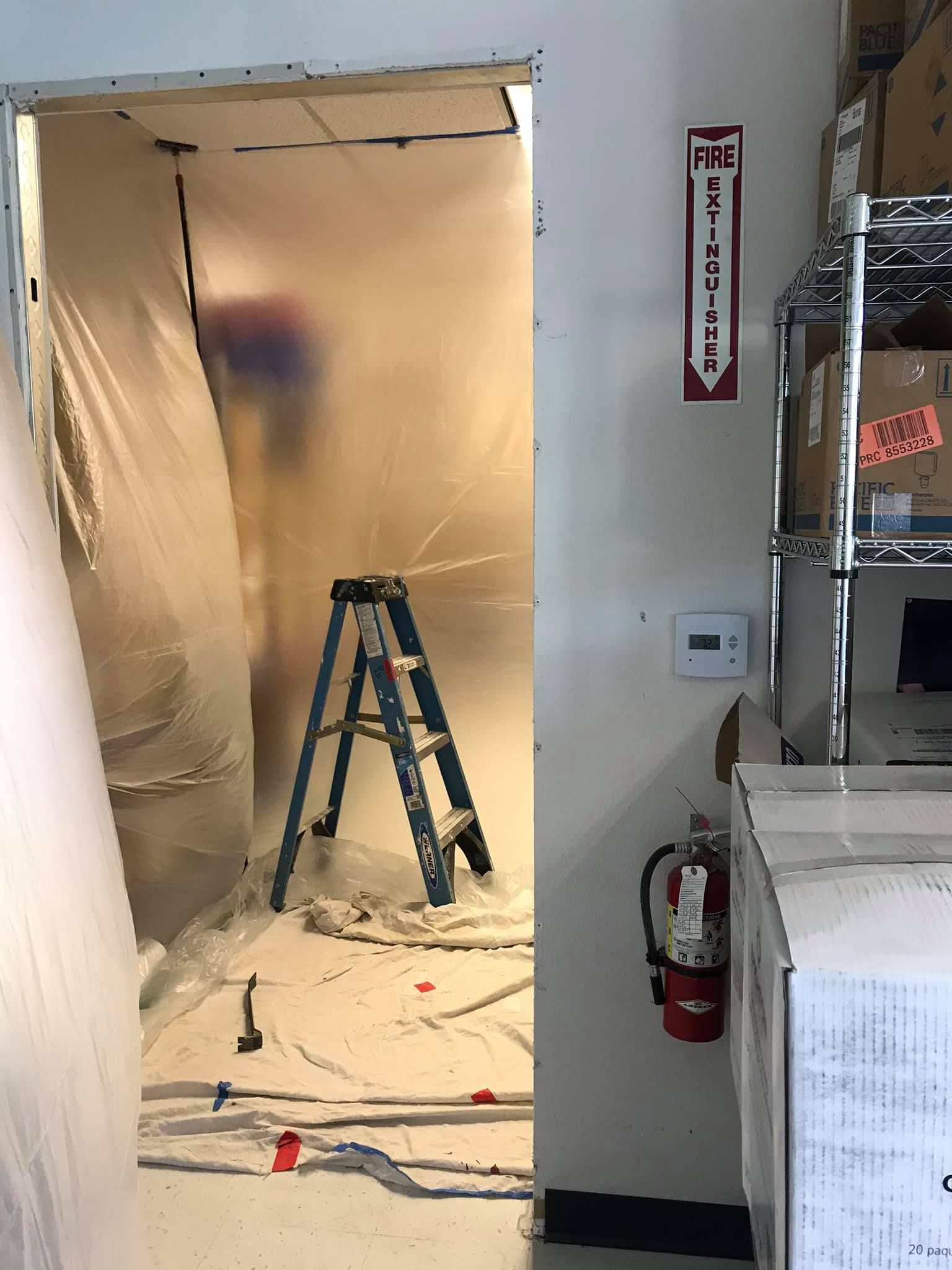 A room with a ladder and a fire extinguisher in it.