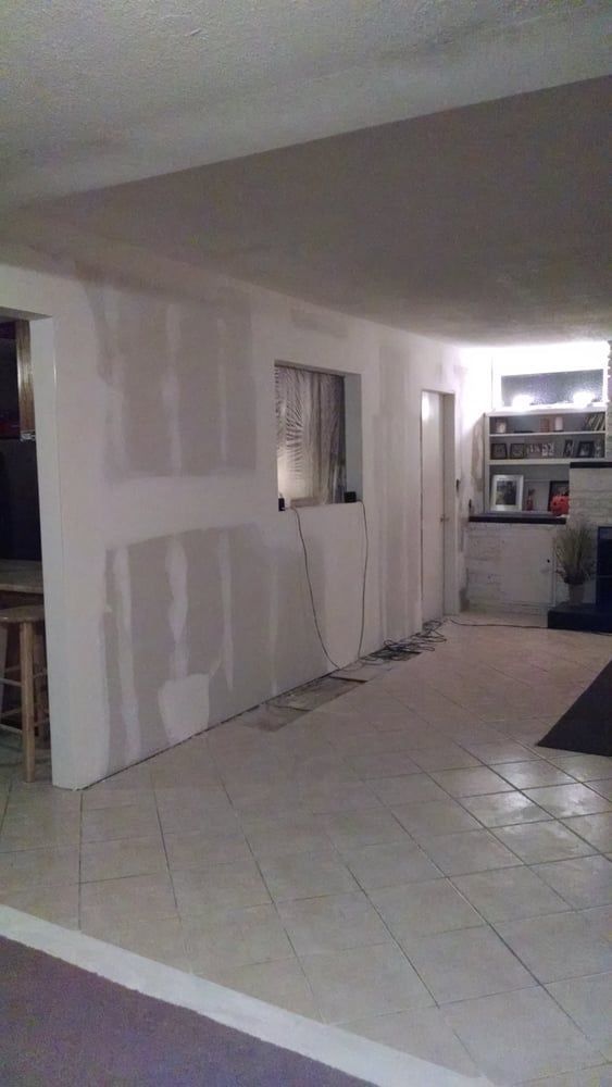 A large empty room with tile floors and white walls.
