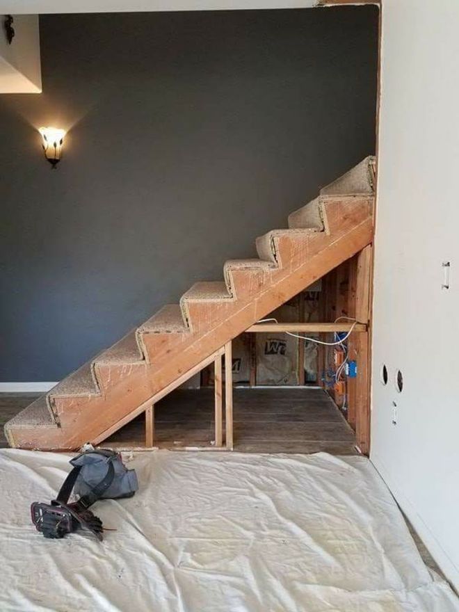 A wooden staircase is being built in a room.