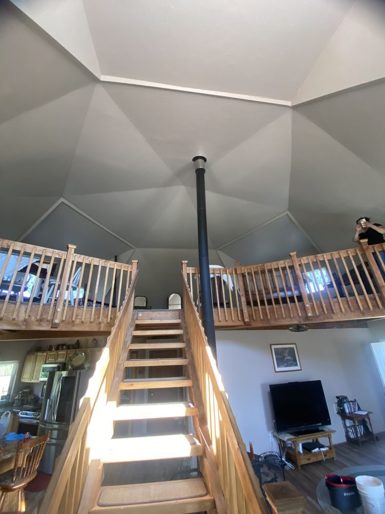 A wooden staircase leading up to the second floor of a dome house.