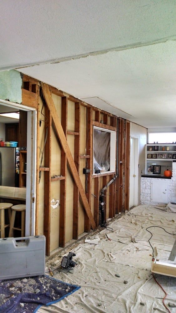 A room with a broken wall and a window in it.