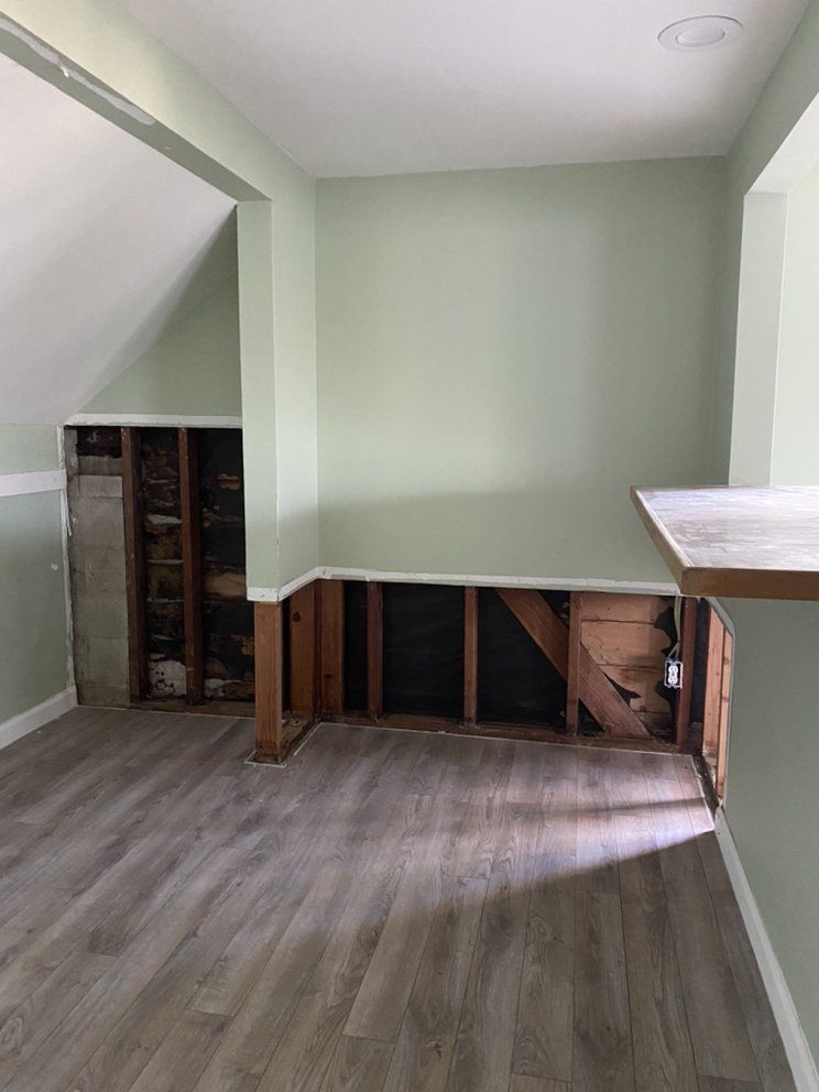 An empty room with a wooden floor and a wooden table.