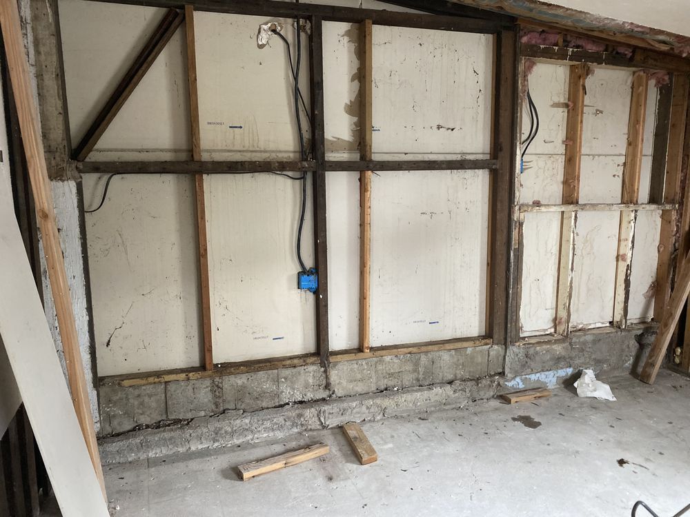 A room with a concrete floor and a wooden frame on the wall.