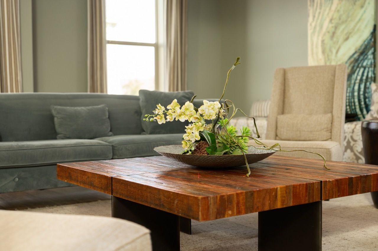Living room with a rustic wooden coffee table, gray sectional sofa, and beige armchair.