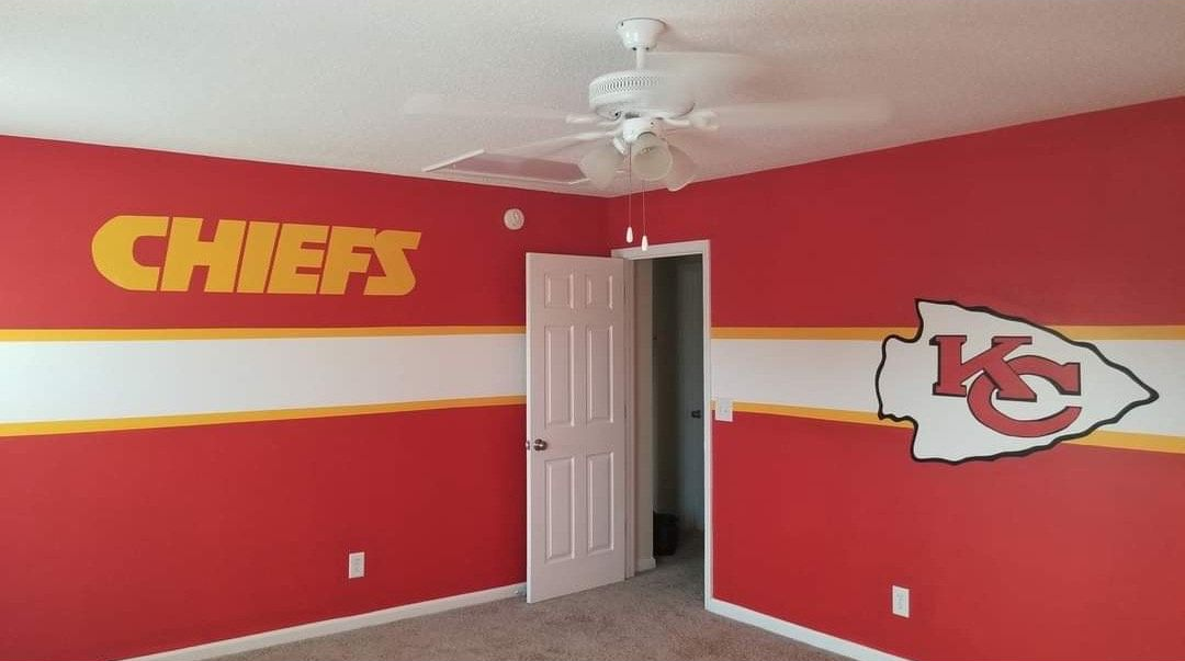 Red, white, and gold Kansas City Chiefs themed bedroom with the team's logo and 