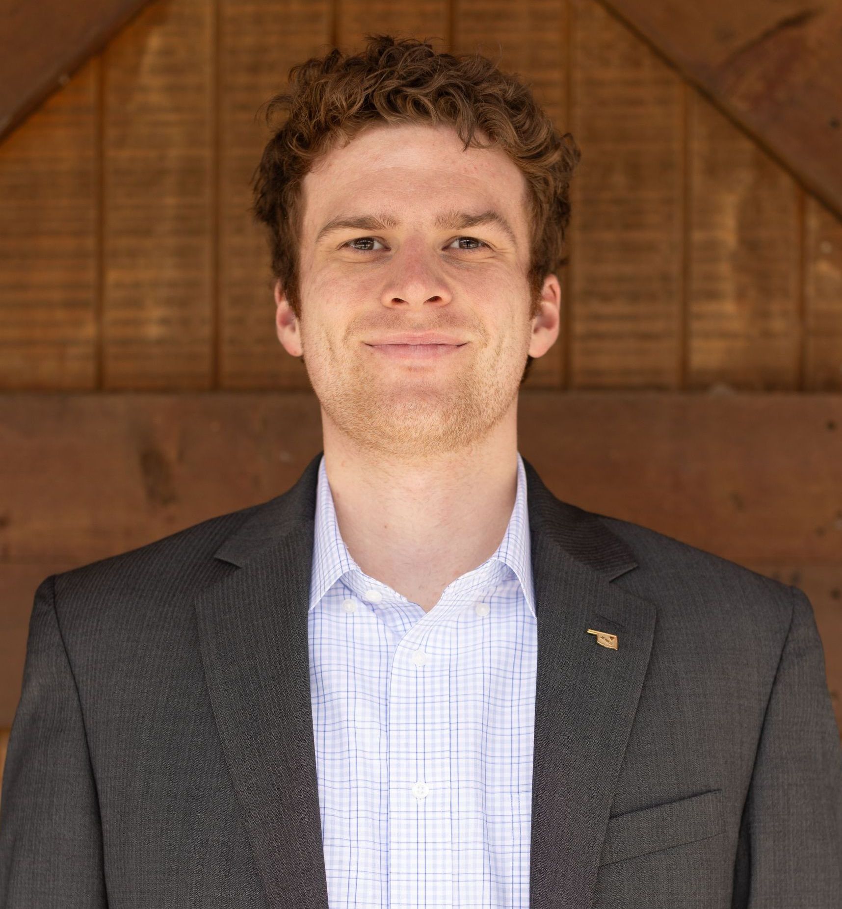 A man in a suit and blue shirt is smiling for the camera.
