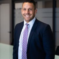 A man in a suit and tie is smiling for the camera.