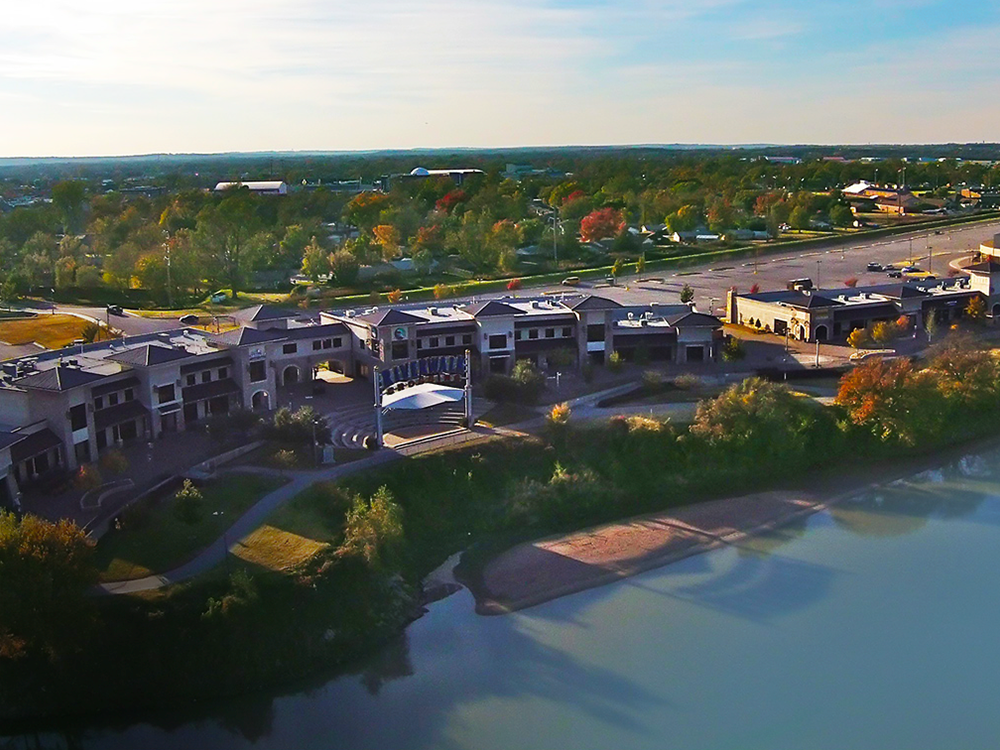 An aerial view of a lake surrounded by buildings and trees.