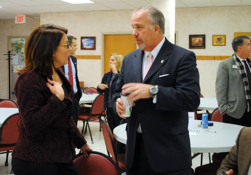 A man in a suit and tie is talking to a woman