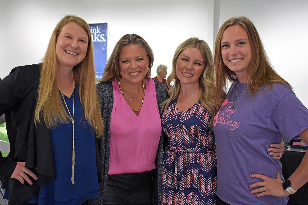 A group of four women are posing for a picture together.