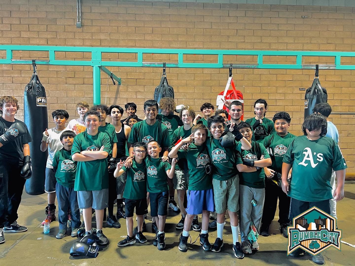 Group of young people in green shirts, boxing in a gym.