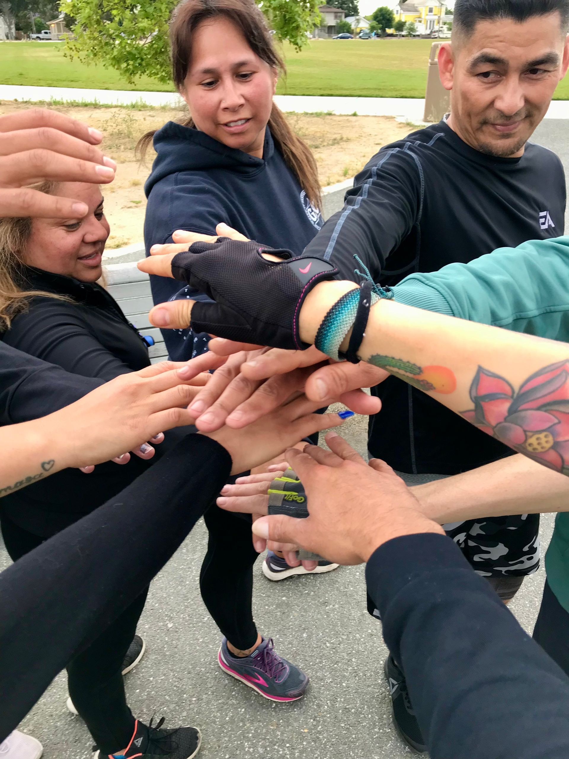 Group of people with hands stacked together, a sign of unity.