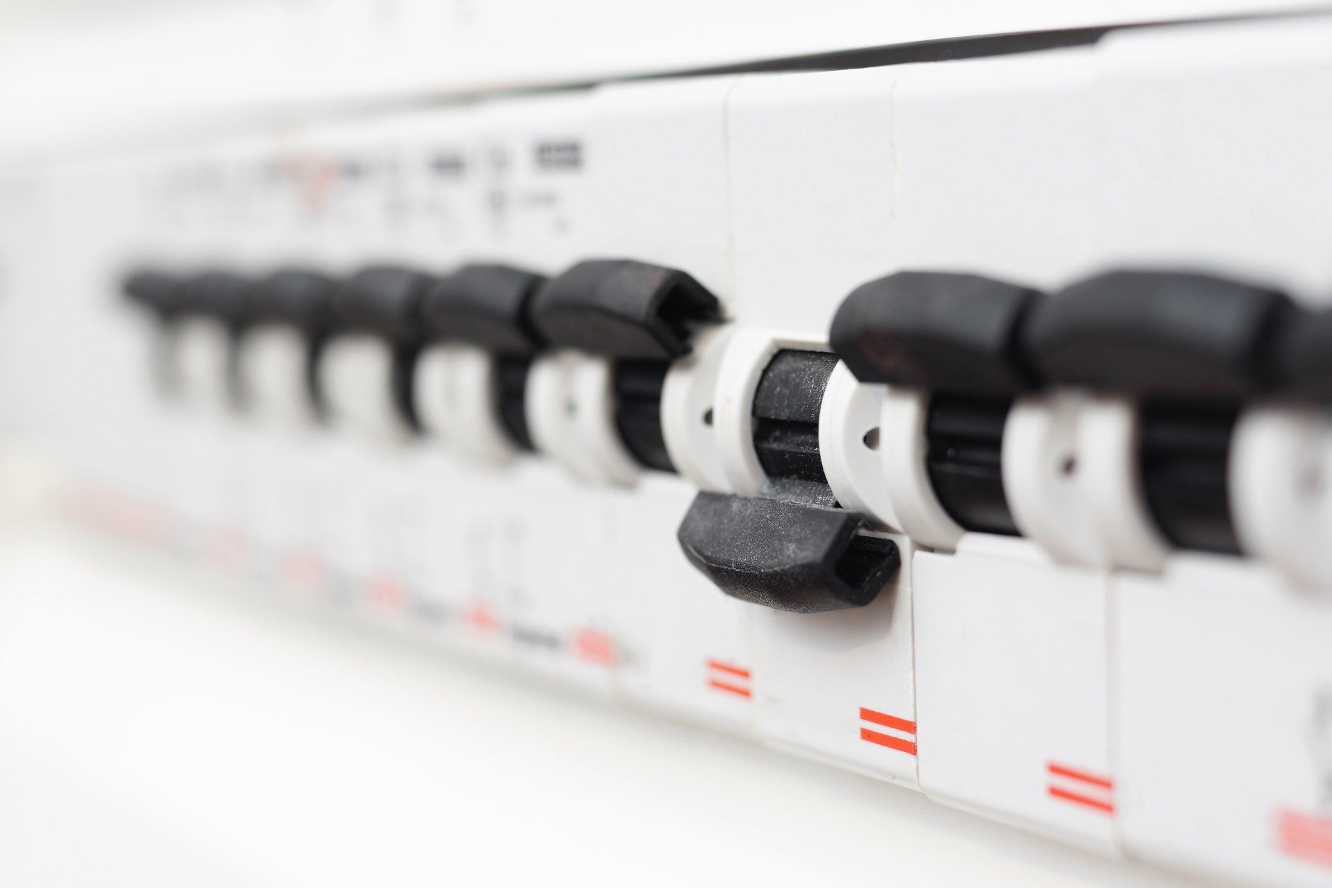A close up of a row of electrical switches on a wall.