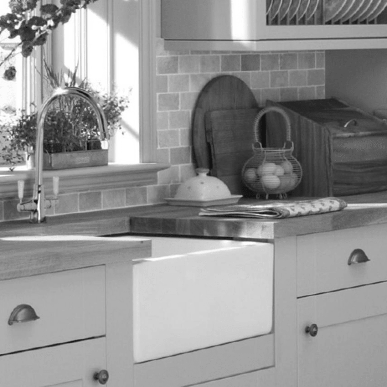 A black and white photo of a kitchen with a sink