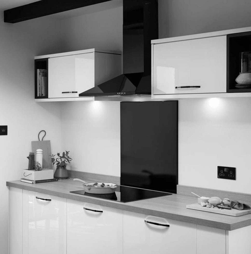 A black and white photo of a kitchen with white cabinets