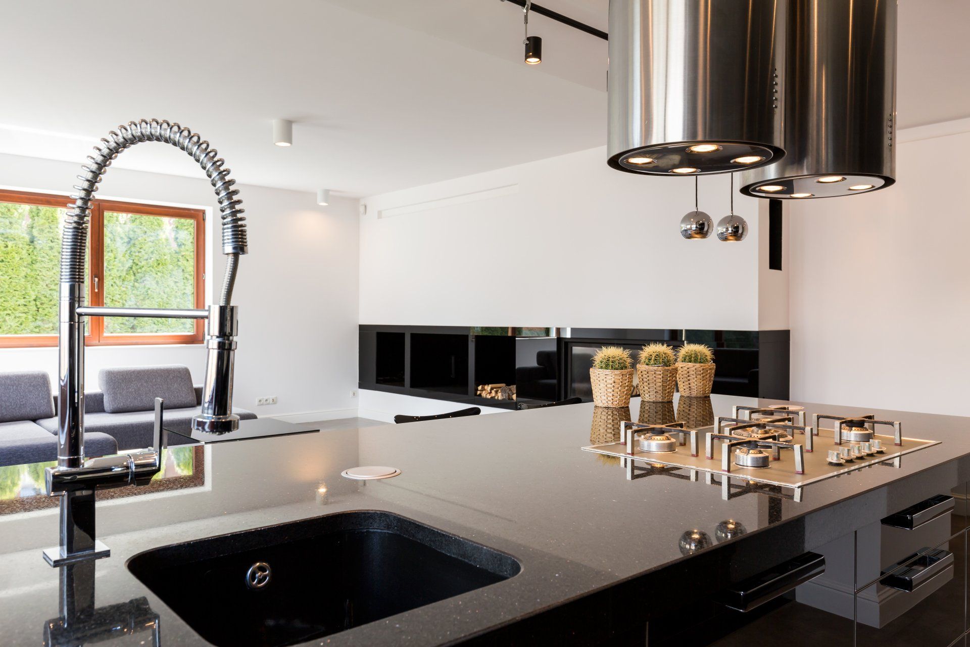 A kitchen with a sink and a stove top oven.